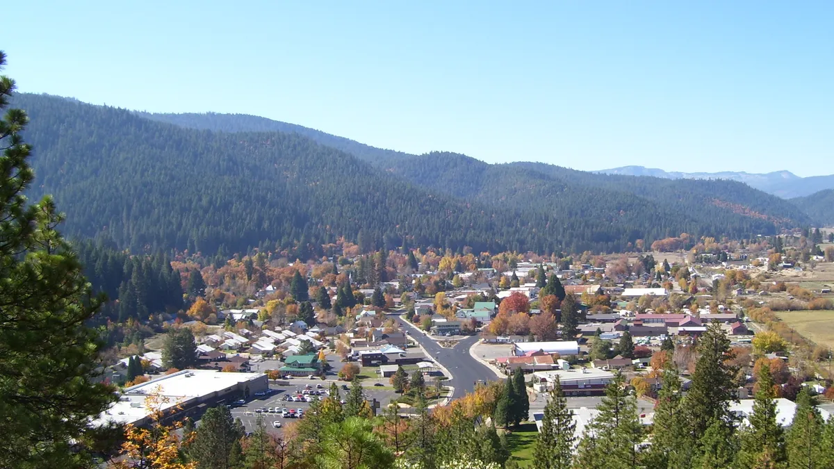 A mountain side view down to a small rural town in autumn.