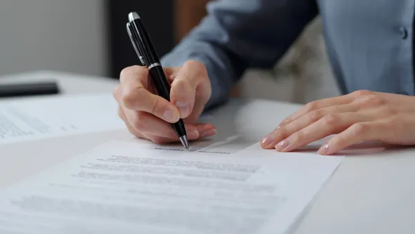 Closeup of businesswoman signing contract in an office.