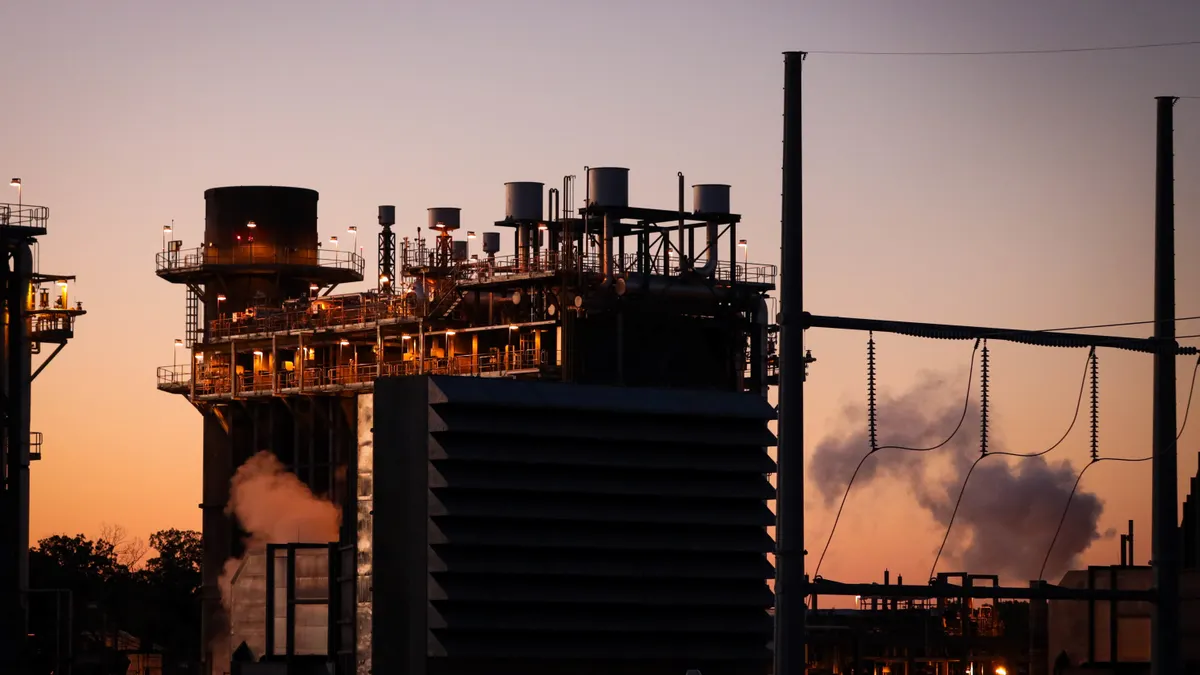 A gas plant is seen against a sunset sky.