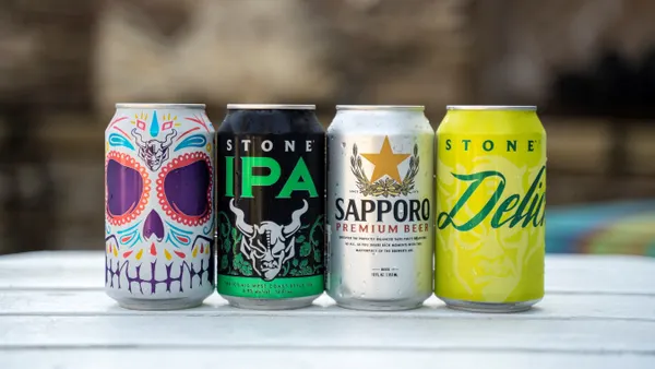 Four beer cans are depicted next to each other on a table.