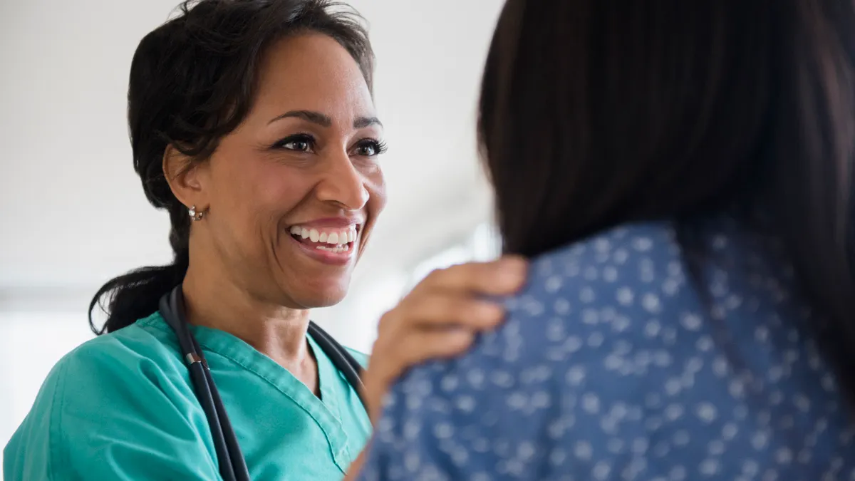 Smiling nurse comforting patient