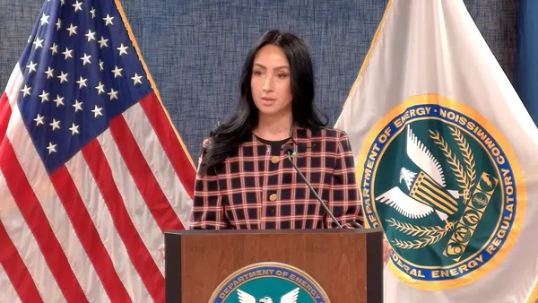 A woman speaks from a podium.