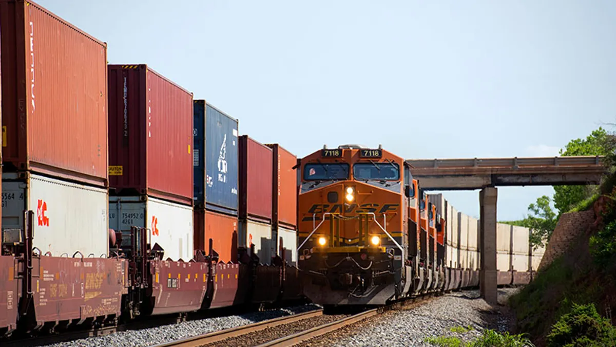 A BNSF locomotive sits by containers in an intermodal facility.