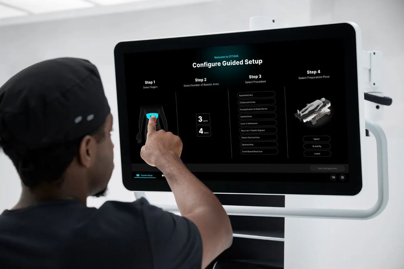 A clinician touches a screen to set up the Ottava surgical robot.