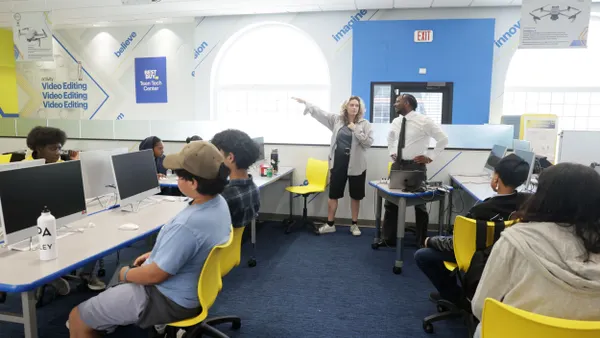 A group of students sits an a computer lab.