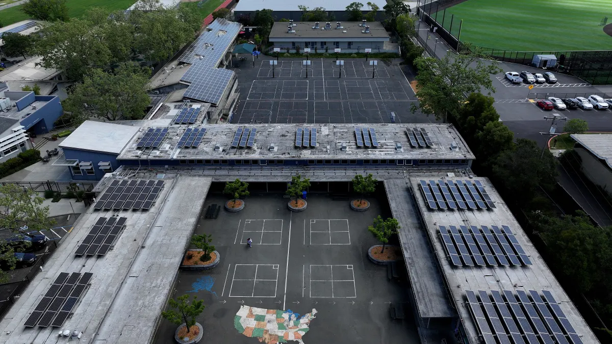 Solar panels are seen on the roof of a school.