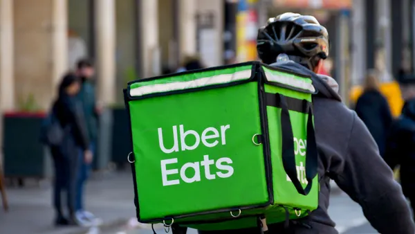 An image of a bicyclist carrying a green backpack that says Uber Eats