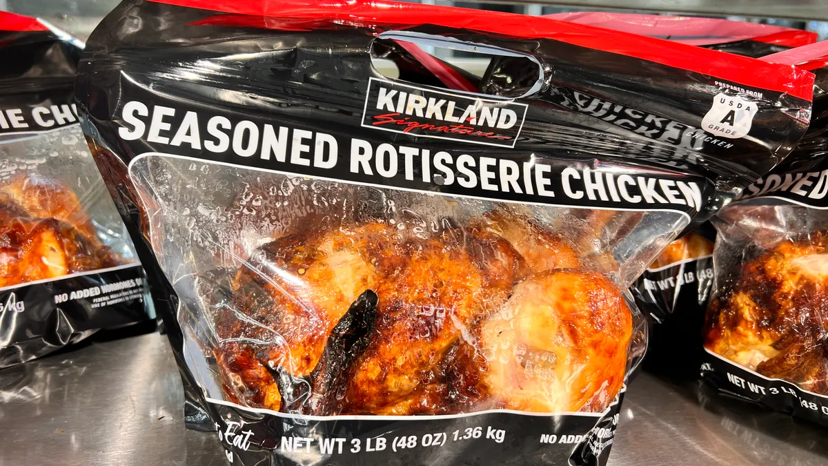 A Costco rotisserie chicken in a flexible plastic bag with red and black branded messaging.