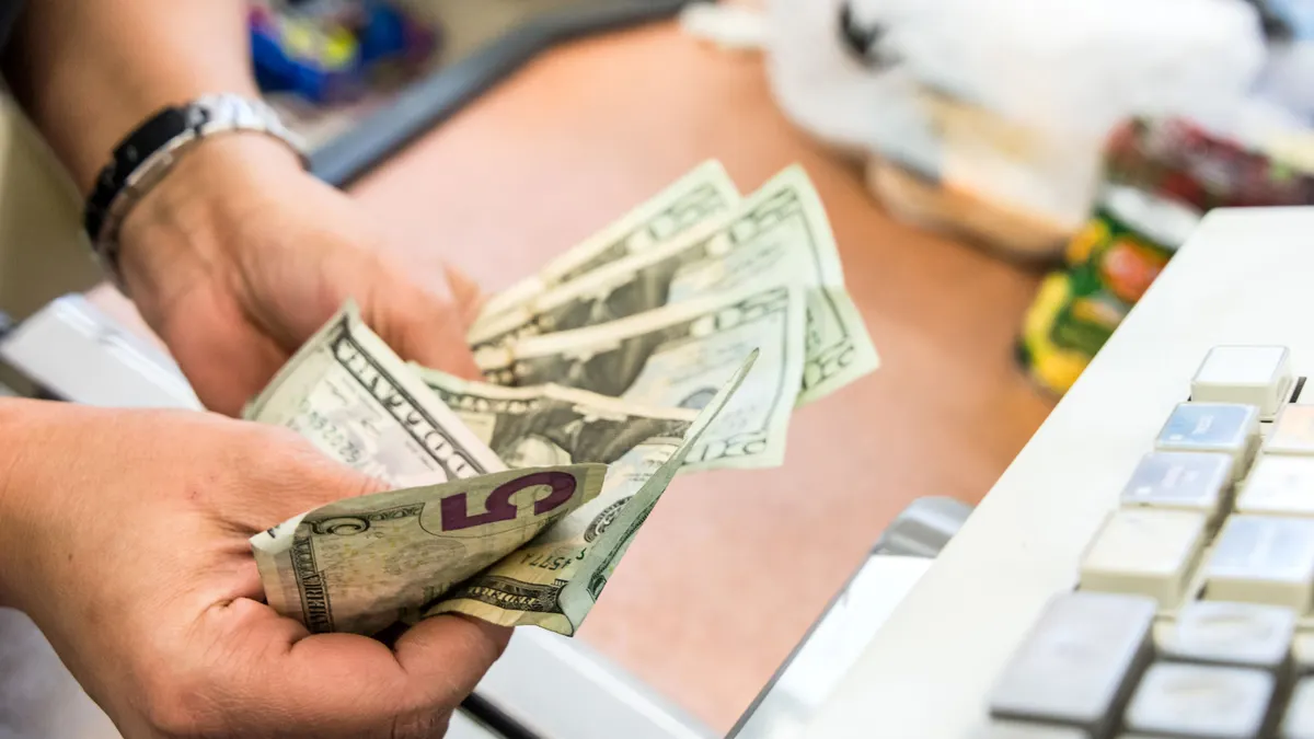 Convenient store cashier counting the cash at the counter