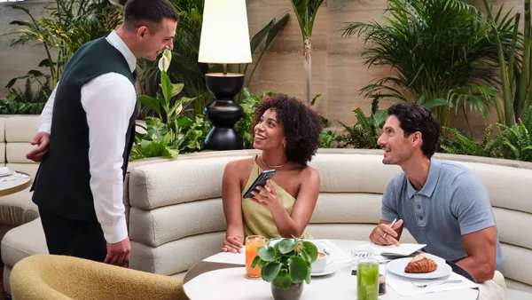 A couple interacts with hotel staff