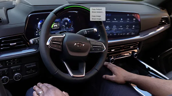 A driver without their hands on the steering wheel using GM's Super Cruise hand-free highway driving feature on a 2025 Tahoe RST SUV.