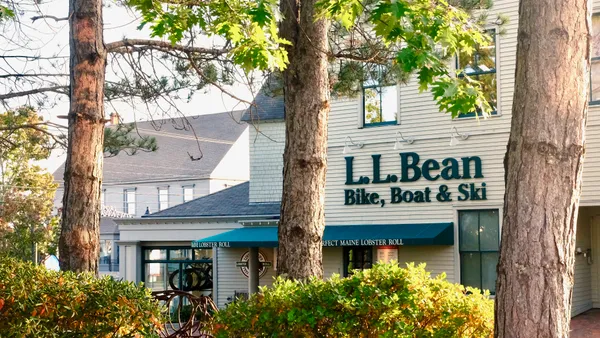 Tall trees in front of a bike, boat and ski store.