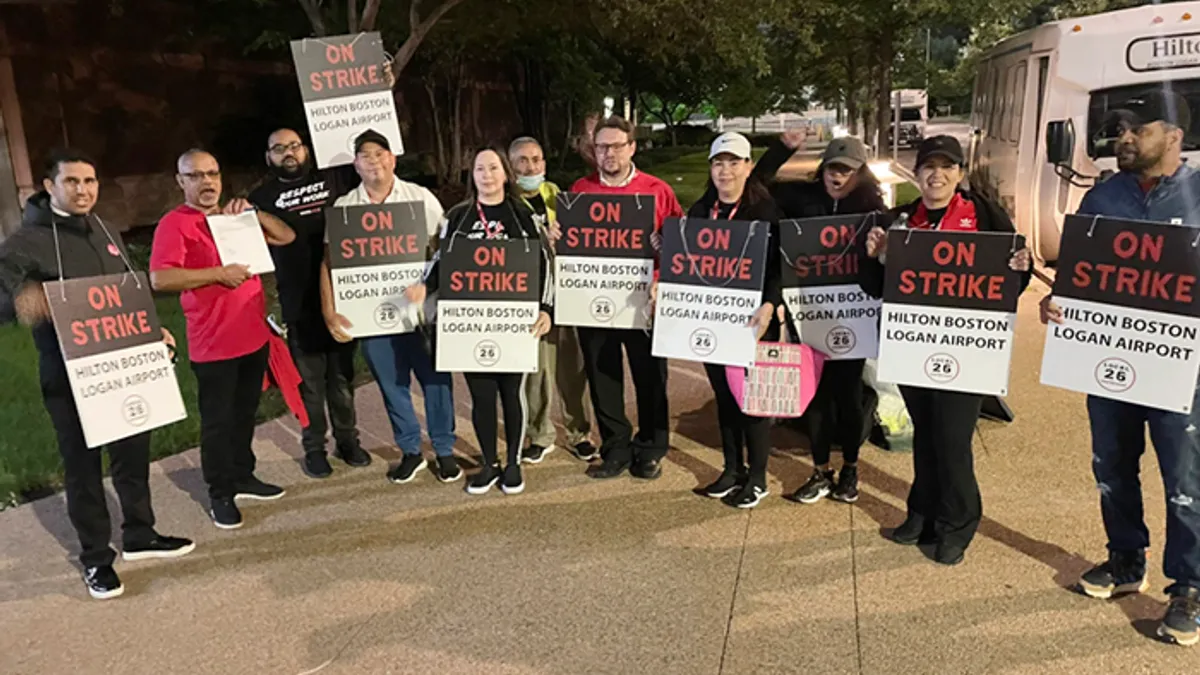 Workers hold signs reading "on strike."