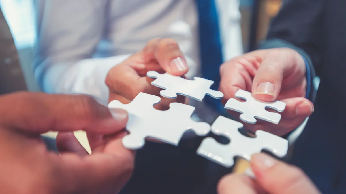 Group of business people holding a jigsaw puzzle pieces. Business solution integration concept.