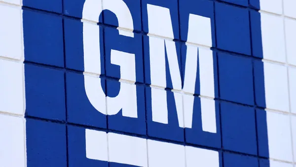 A blue sign with white lettering reads "GM."