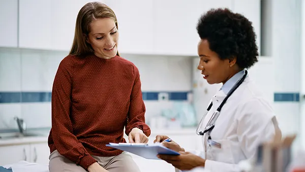 A doctor meeting with a smiling patient.