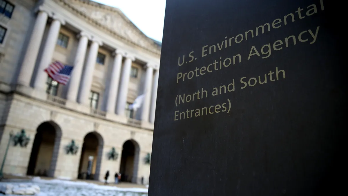 A photo of the EPA entrance sign in the foreground of the agency's building