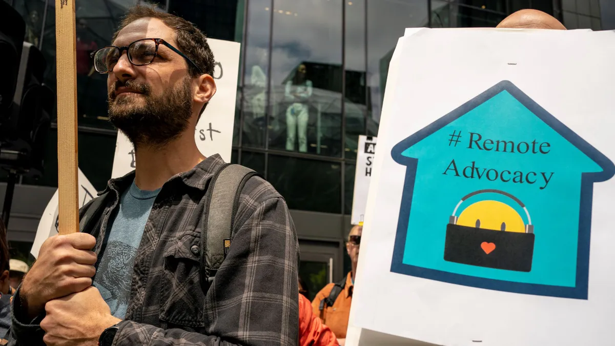 Employees on strike hold a sign that says "#RemoteAdvocacy."