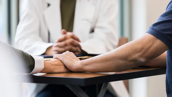 Two people hold hands at the doctor's office