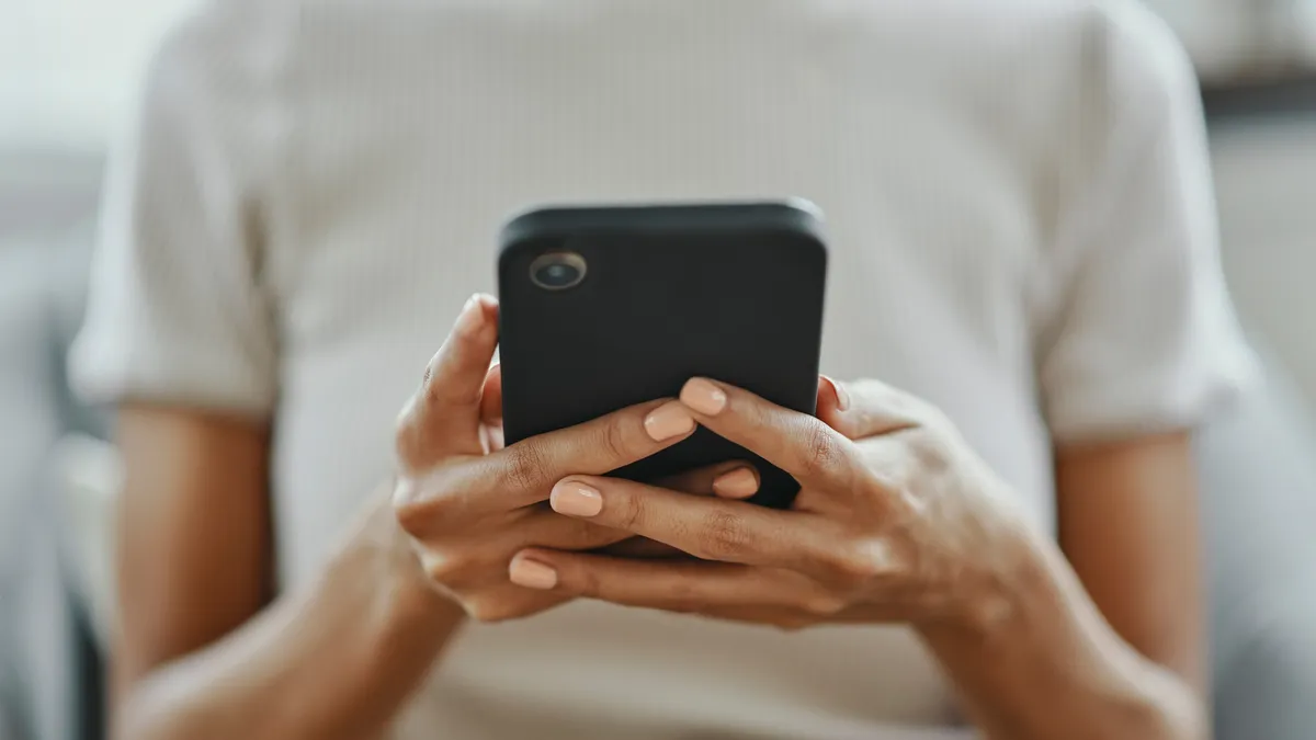 A person holding a cell phone with both hands.