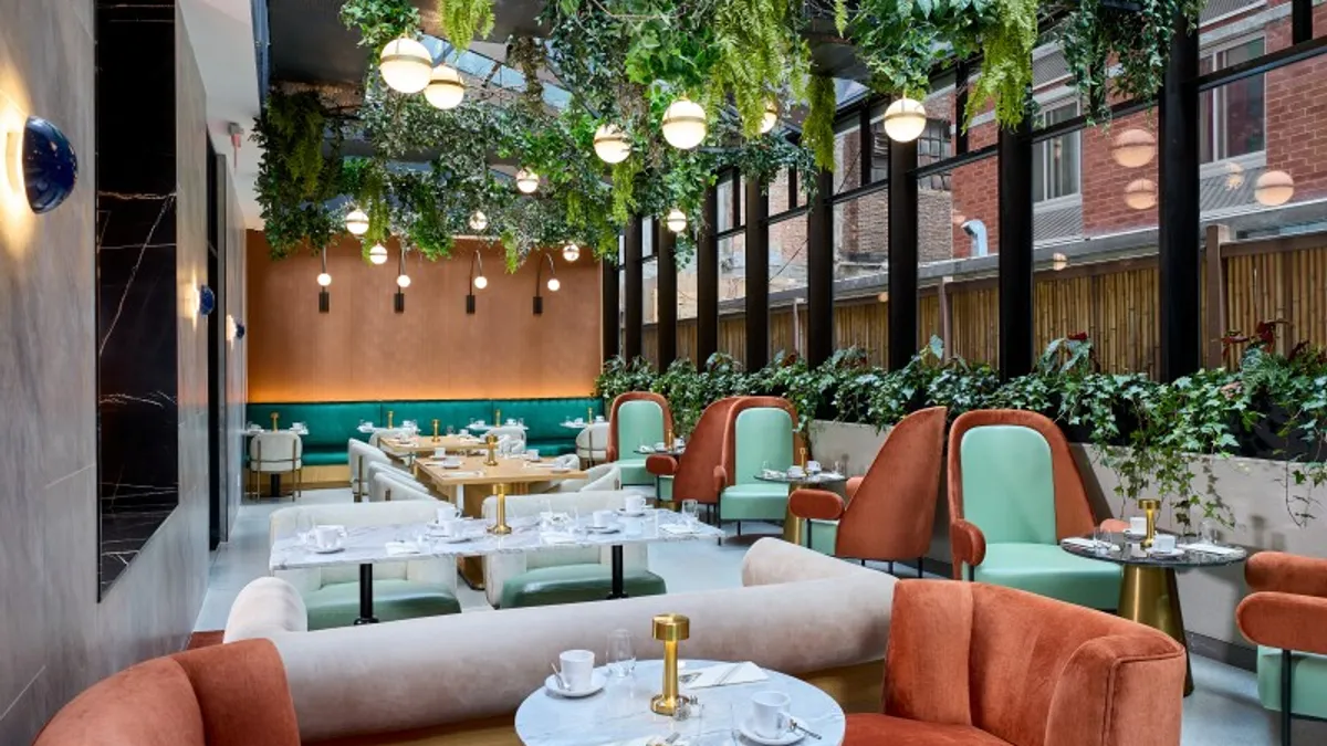 Rust-colored armchairs and mint-green seat cushions in the restaurant George's Nephew.