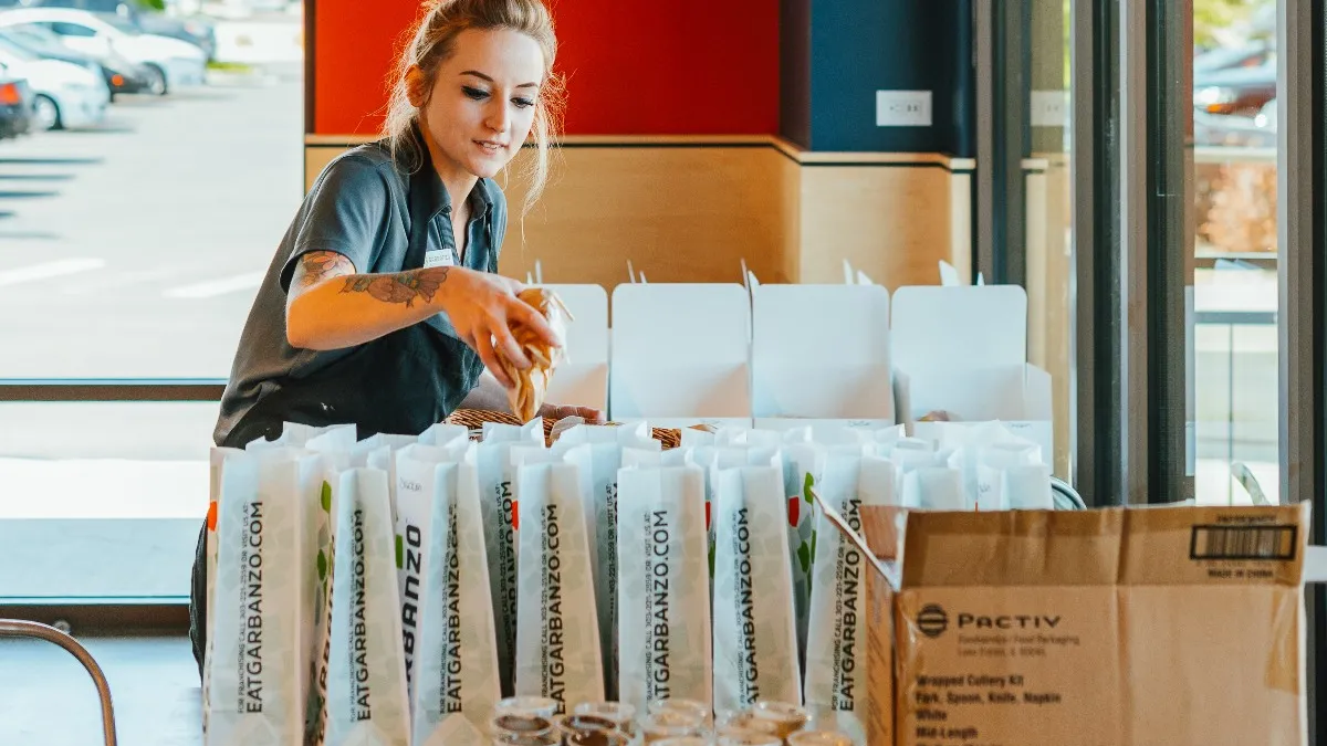 Garbanzo Mediterranean Fresh employee prepares takeout meals