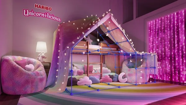 A brand photo of a room in the Haribo vacation destination with a blanket fort, pillows and lights.