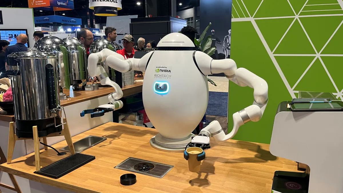 A white, egg-shaped robot with silver and white squiggly arms makes a latte.