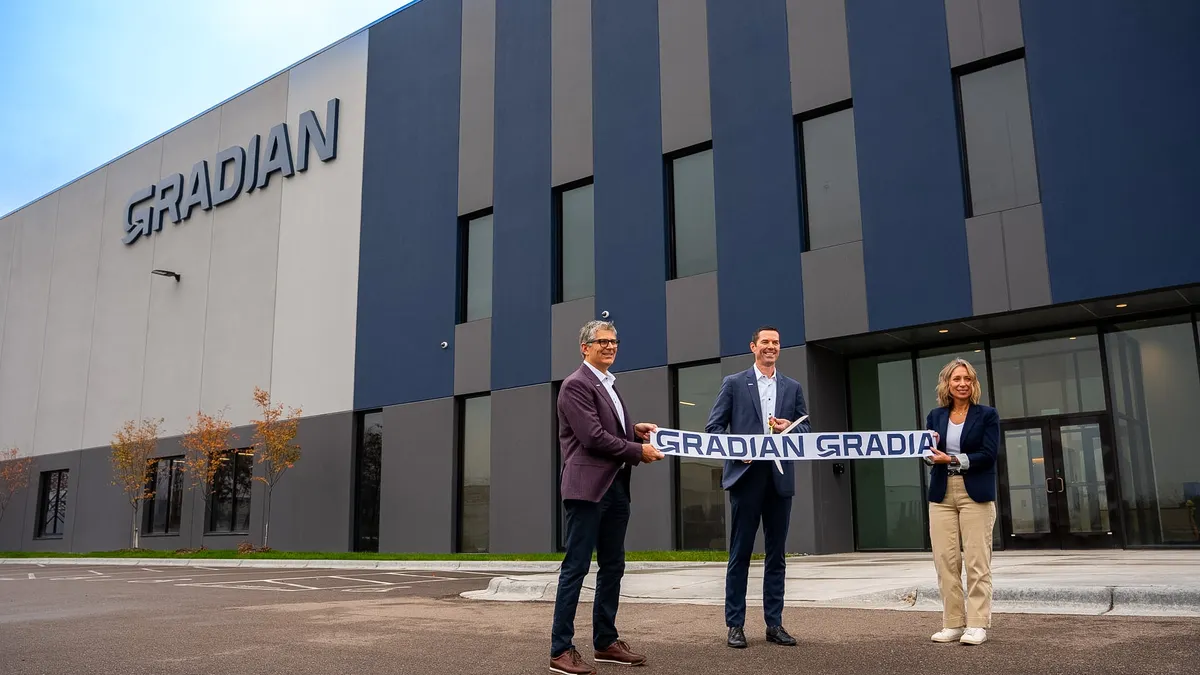 Two people stand in front of Gradian's manufacturing facility in Dayton, Minnesota