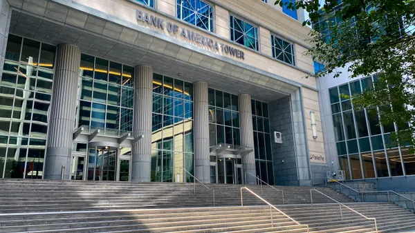 A stone building facade shows the words "Bank of America Tower" above a glass paneled entrance, with stone steps below.
