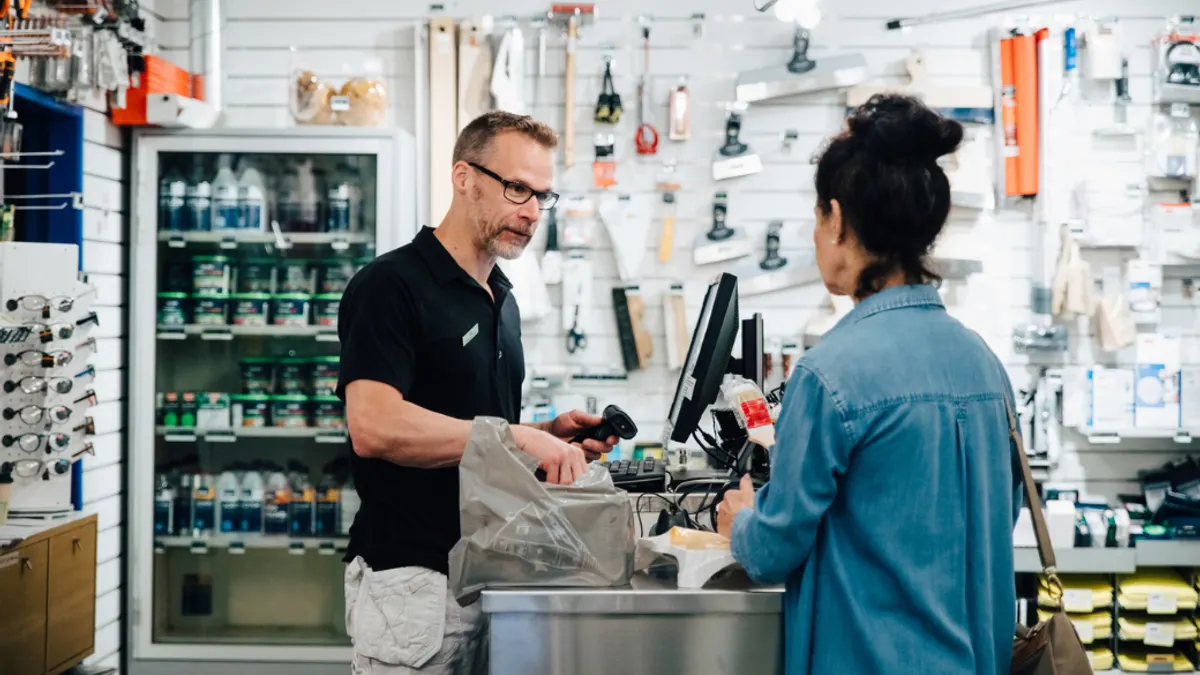 Retailer and customer interacting as customer is checking out at a hardware store.