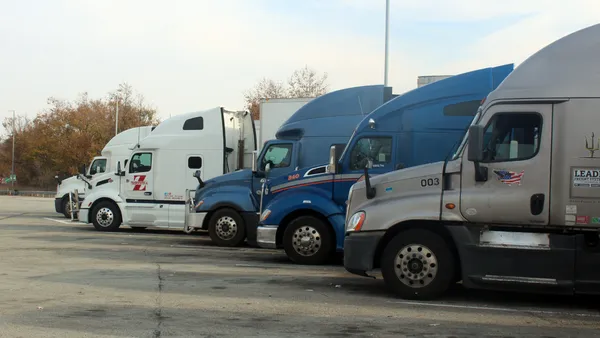 Tractor-trailers at a rest stop on the Pennsylvania Turnpike in a truck parking area near fueling pumps in the Pittsburgh suburbs.