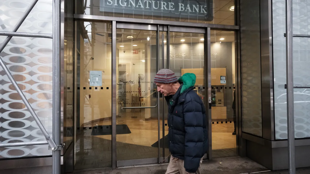 People walk by a branch of Signature Bank.