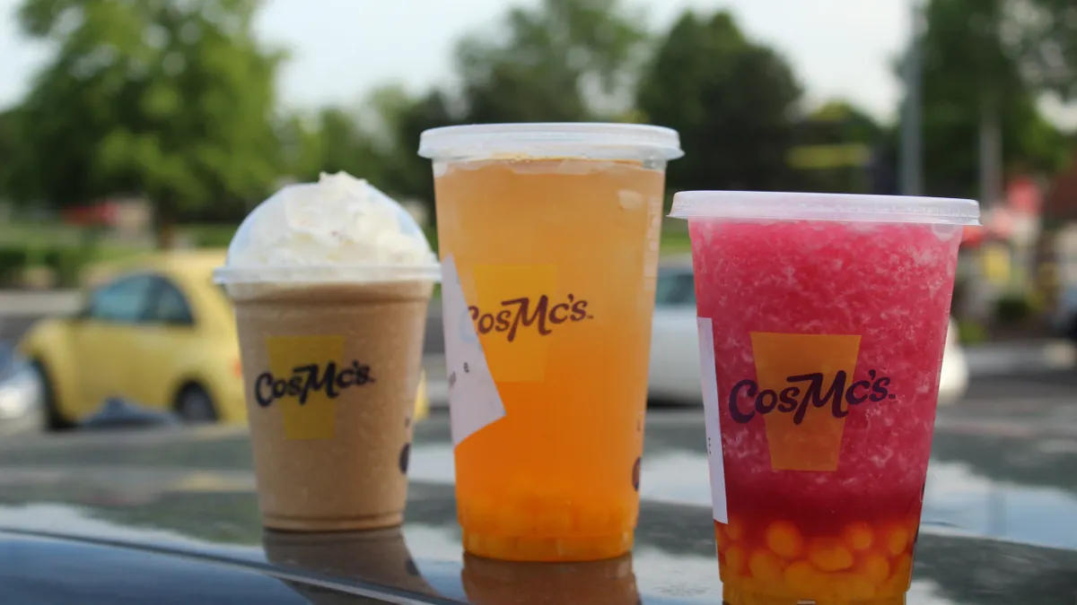 Three fast food beverages stand in line.