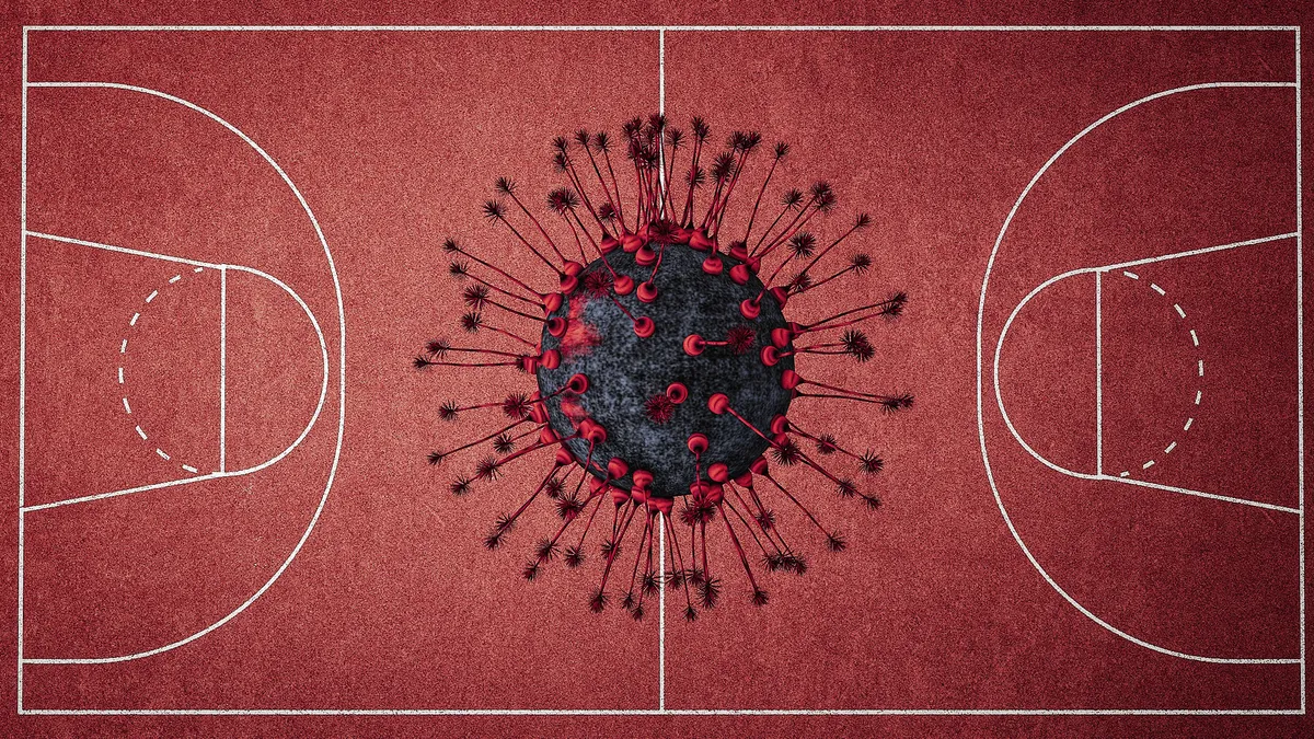 Viewed from above, a rendering of the COVID-19 virus sits in the center of a clay, red basketball court.