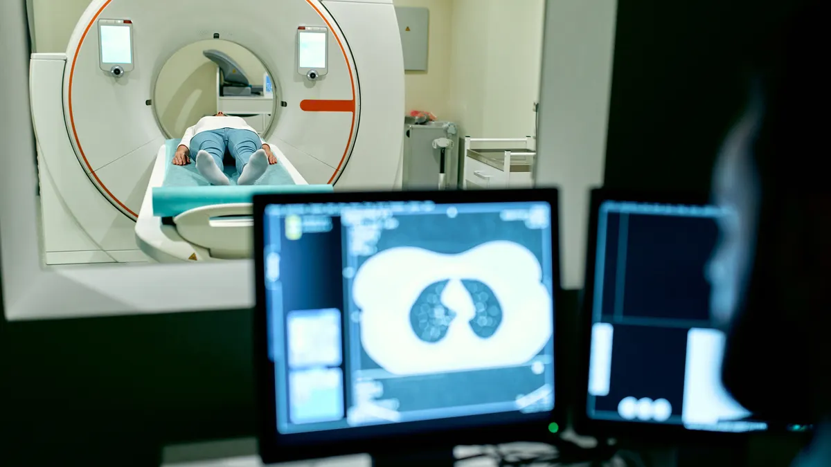 A patient undergoes a CT scan under the supervision of a radiologist.