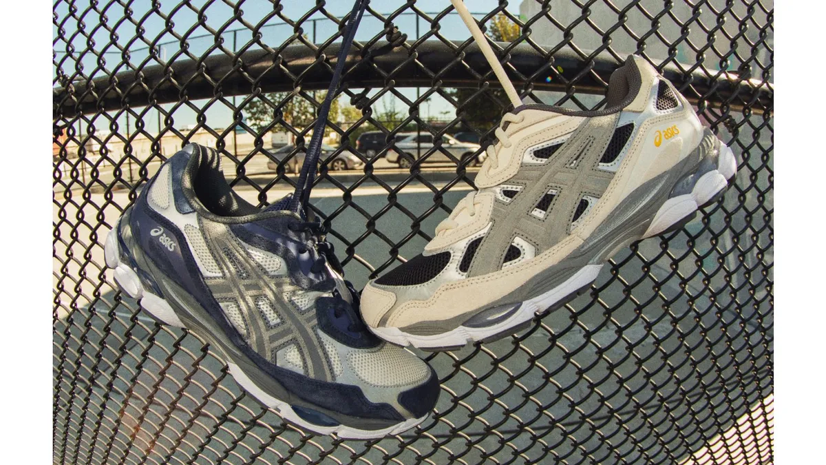 Two sneakers hang off a wire fence