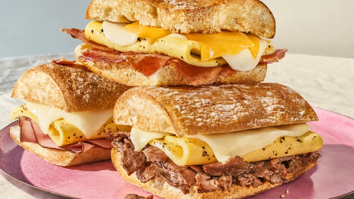 Three breakfast sandwiches from Panera stacked in a pyramid.