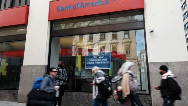 Pedestrians pass by a Bank of America branch.