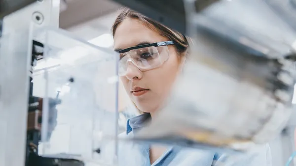 Woman in a lab wearing safety goggles