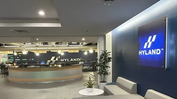 An office building lobby with the Hyland corporate logo visible on a reception desk.