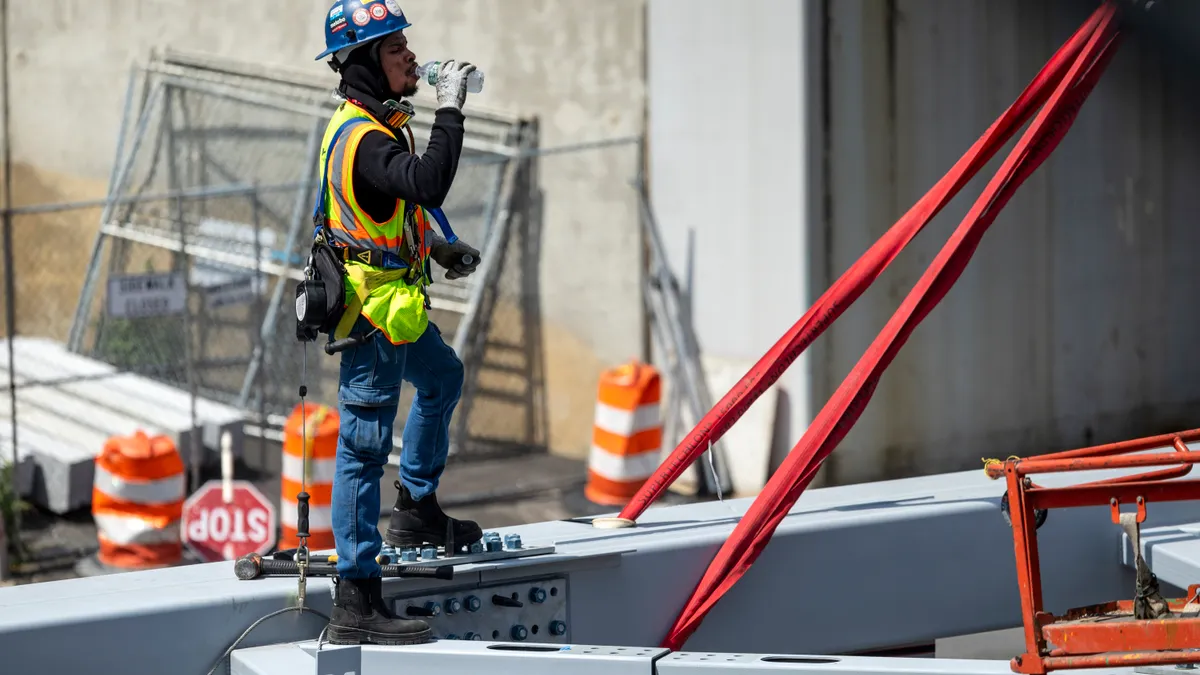 Worker prepare to lift a new pedestrian bridge into place at the Stamford Transportation Center on August 26, 2023 in Stamford, Connecticut.