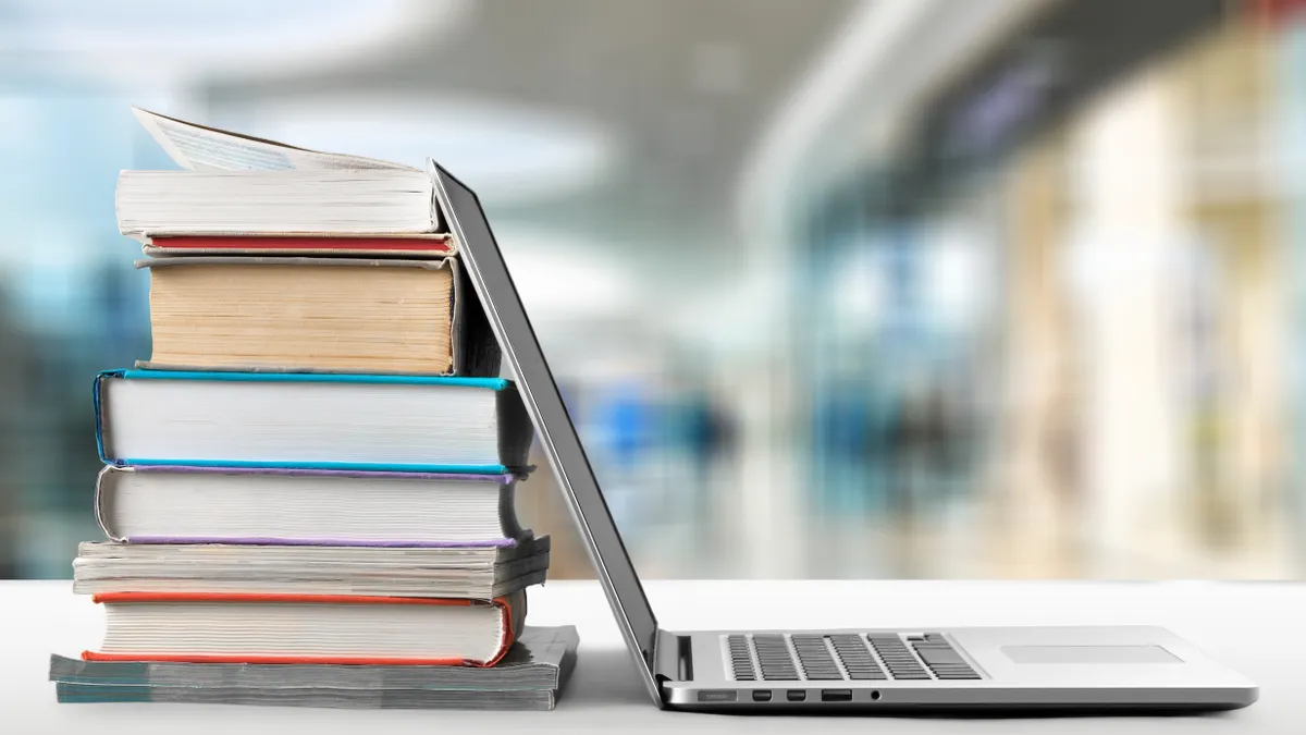 A picture of books next to a computer