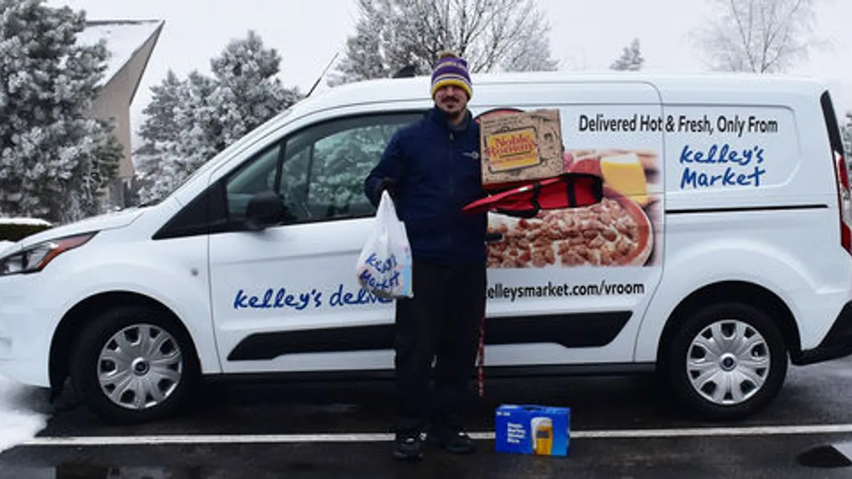 A photo of a person standing in front of a delivery van for Kelley's Market.