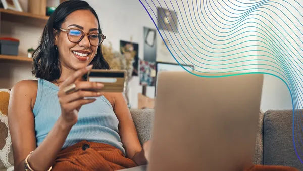 Woman on couch with laptop credit card and online shopping payment and ecommerce with fintech