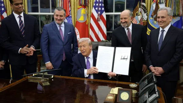 U.S. President Donald Trump displays a signed executive order as U.S. Sen. Ted Cruz (R-Texas), Commerce Secretary Howard Lutnick and White House artificial intelligence and crypto czar David Sacks look on in the Oval Office of the White House.