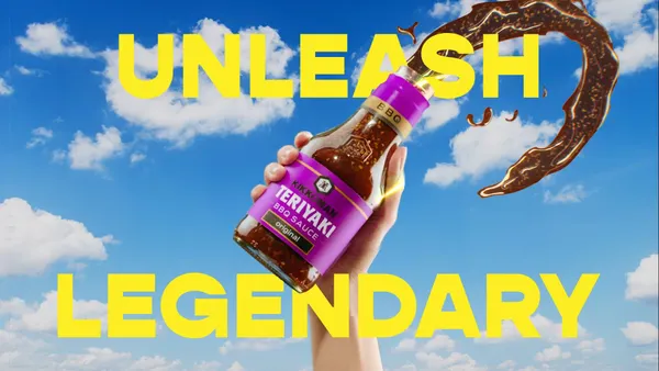 A hand raised in the air holds a bottle of Kikkoman against a blue sky with Unleash Legendary in bold yellow lettering.