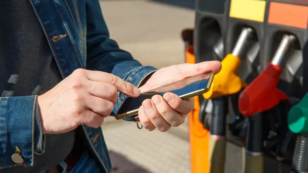 A smartphone being used to pay at a fueling station.