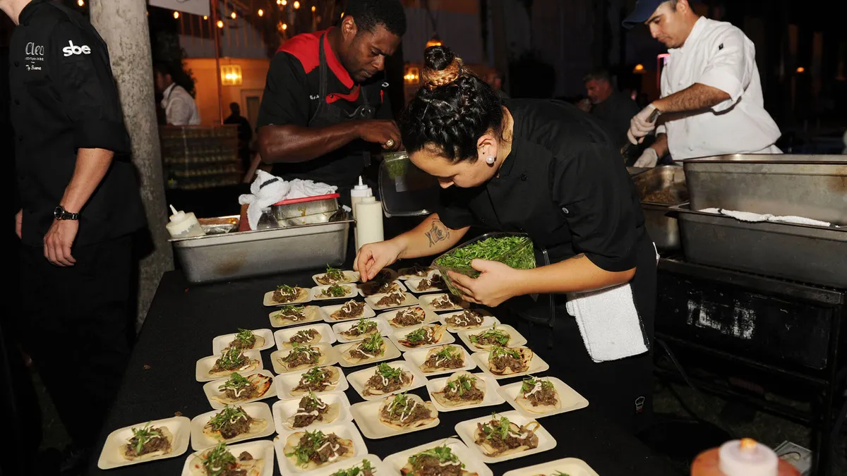 A chef prepares tacos.