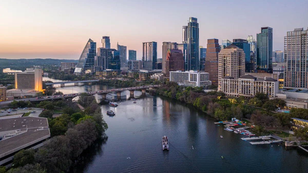 An aerial view of a city skyline at sunset over a river.